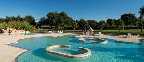 A swimming pool with multiple lanes and a surrounding deck area with lounge chairs.