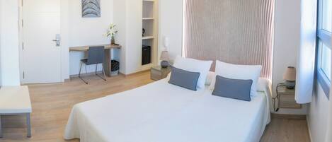Une chambre d’hôtel moderne, dotée d’un grand lit, d’un bureau et d’une chaise.