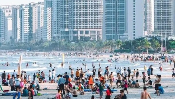 A beach with people and buildings in the background. - An Binh Tai Hotel (Da Nang)