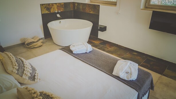 A modern bathroom with a freestanding bathtub, a large mirror, and a flat-screen TV mounted on the wall. - Casa Ziazì (Monopoli)
