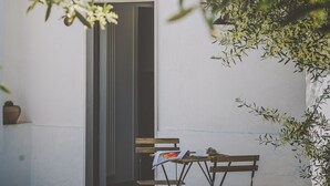 An outdoor seating area with a table and chairs, a doorway, and a potted plant. - Casa Ziazì (Monopoli)