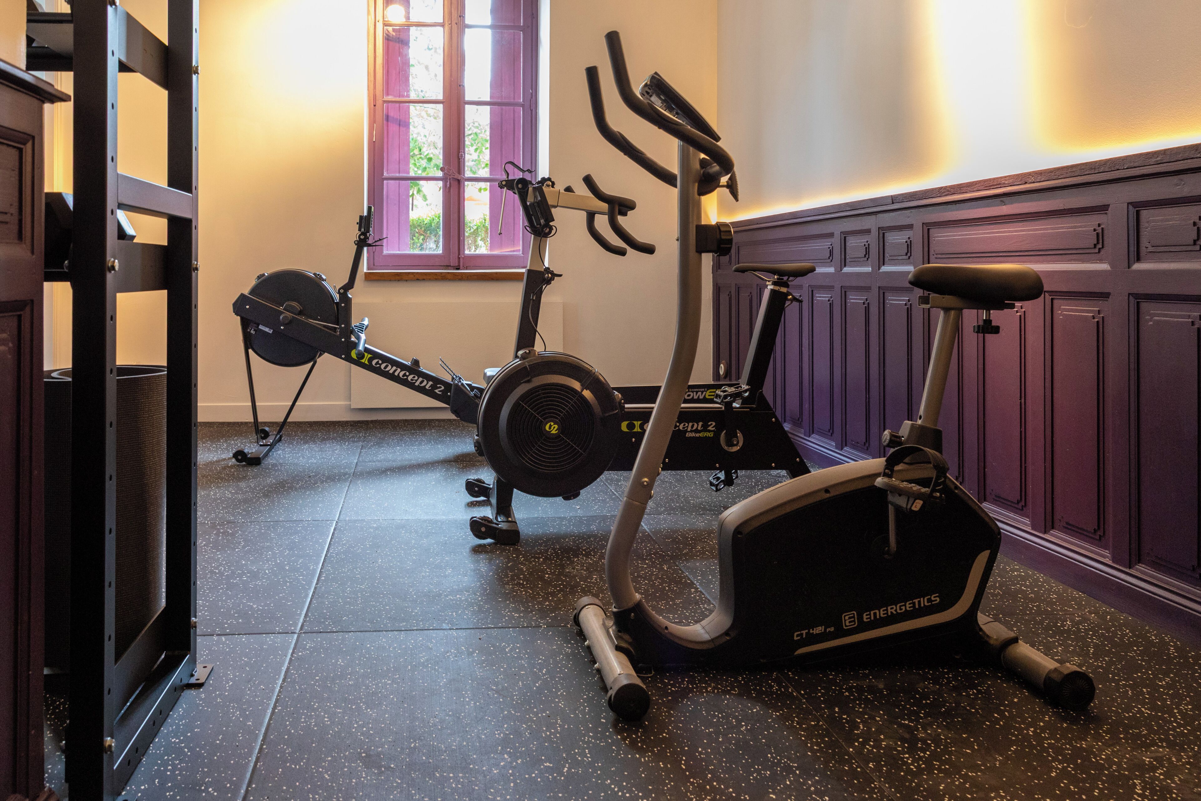 Une salle de sport à domicile équipée de vélos d’appartement et d’un appareil d’entraînement elliptique.