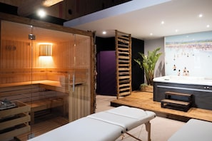 A sauna room with a glass enclosure, a wooden bench, and a massage table. - Village Castigno - Wine hotel & resort (Assignan)
