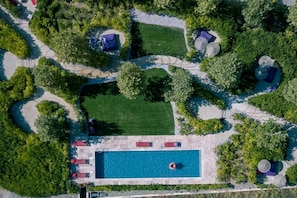 An aerial view of a property with a swimming pool, lounge areas, and a well-maintained lawn. - Village Castigno - Wine hotel & resort (Assignan)