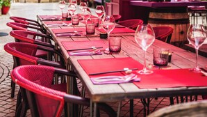 A restaurant with outdoor seating, red umbrellas, and wine glasses on tables. - Village Castigno - Wine hotel & resort (Assignan)
