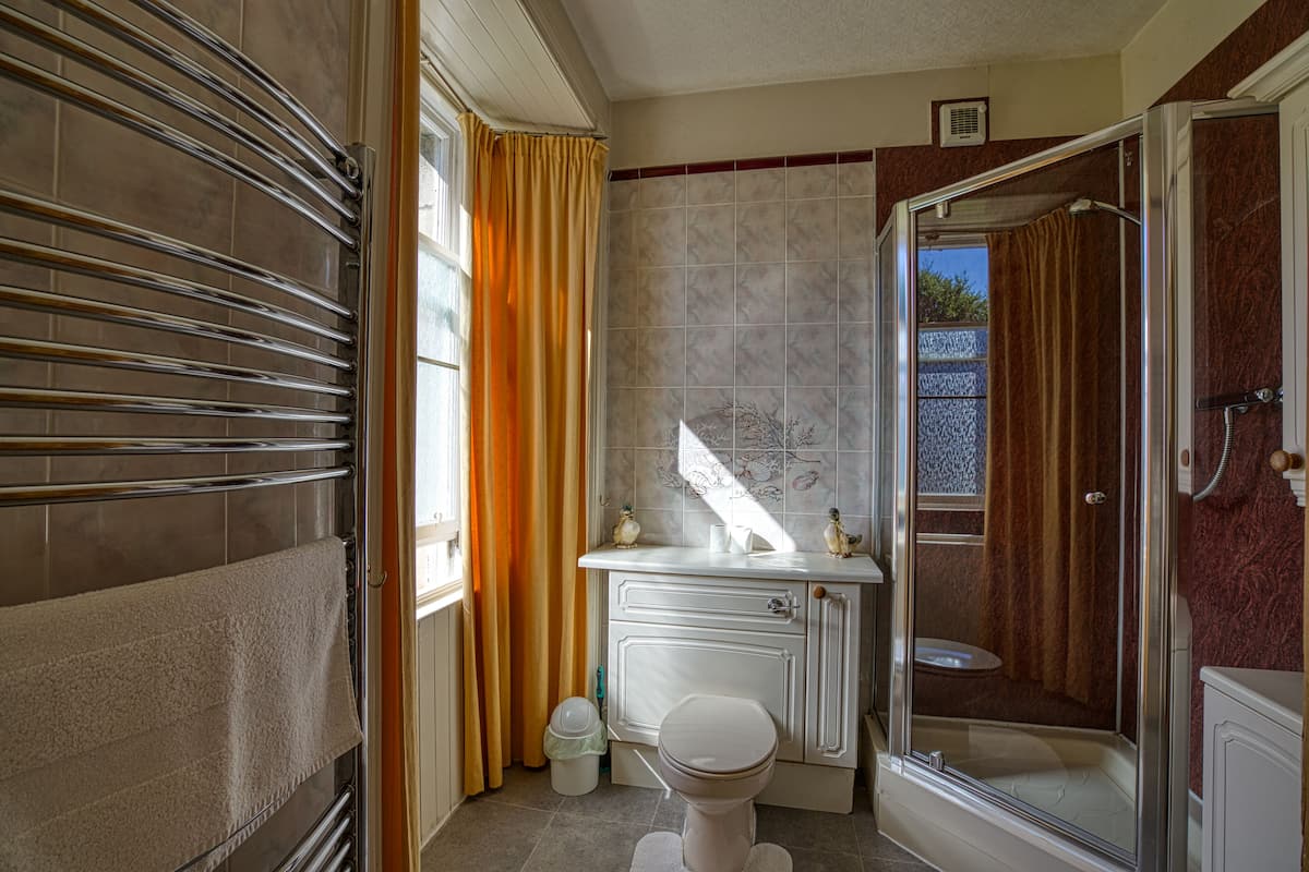 A bathroom with a shower, toilet, and vanity.