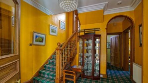 A staircase with wooden railings and a green plaid carpet. - Woodlands Bed & Breakfast (Dornoch)