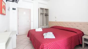 Una camera da letto con un letto, un armadio, un comodino e una scrivania.