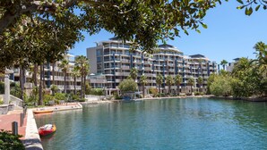 A waterfront hotel with multiple balconies, a dock, and a calm river. - 606 Juliette B (Cape Town)