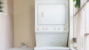 A compact laundry room with a washing machine and a sink.