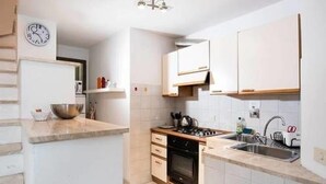 A modern kitchen with white cabinets, a stove, and a sink. - Luna (Florence)