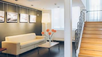 A modern living room with a sofa, coffee table, and artwork on the wall.