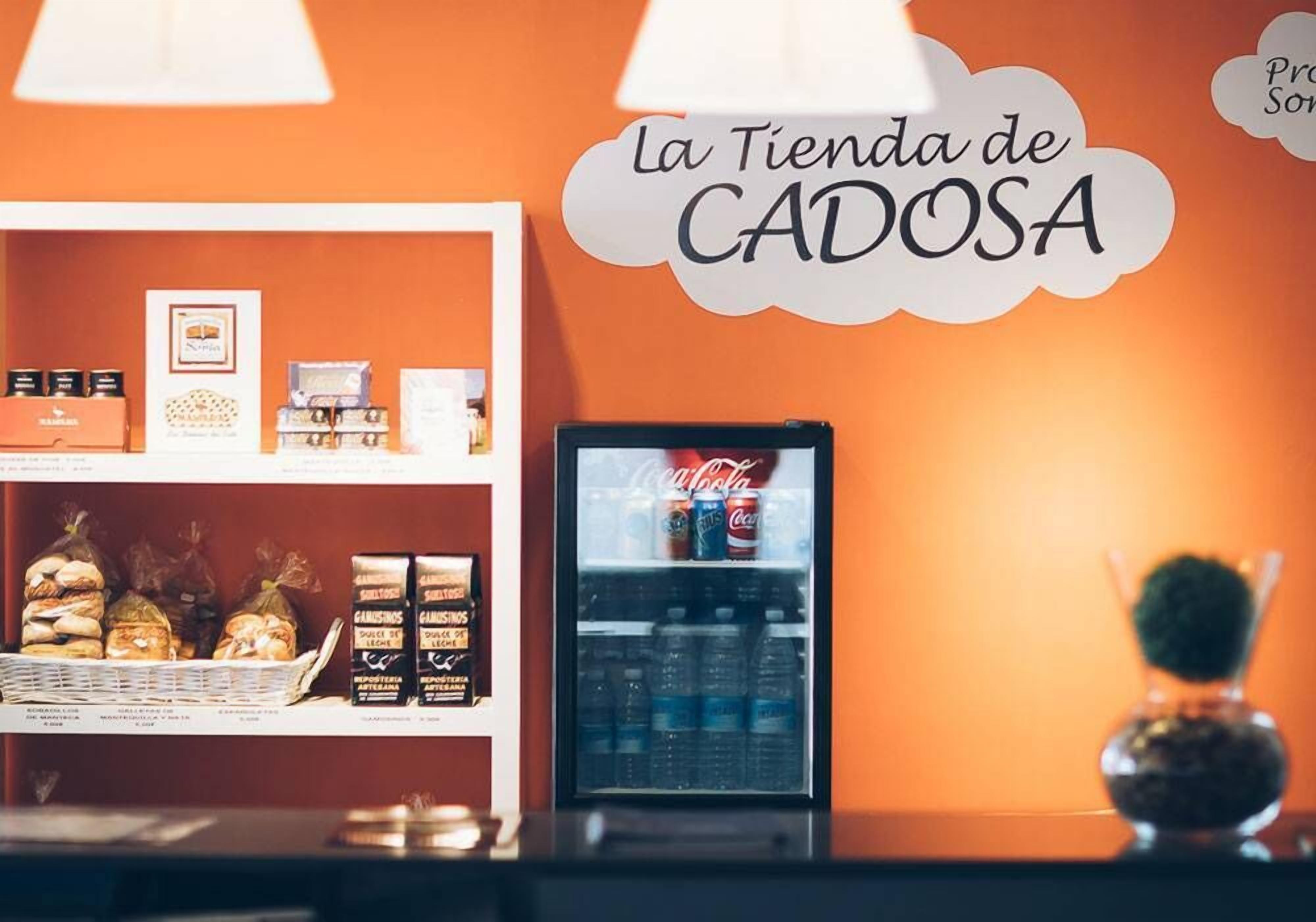 Un bar de aperitivos con un refrigerador de Coca-Cola y una exhibición de productos.