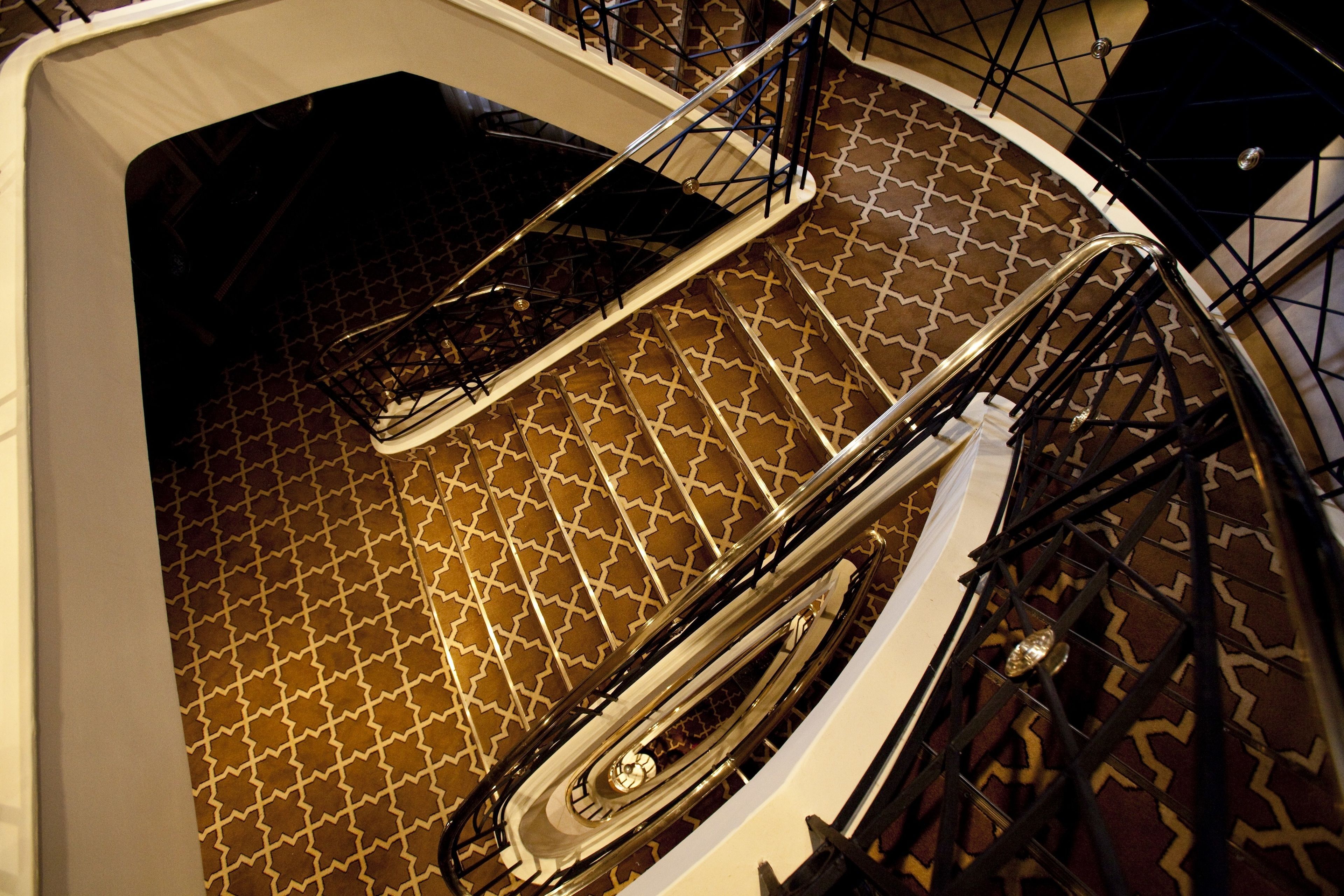 A spiral staircase with a patterned floor and metal railings.