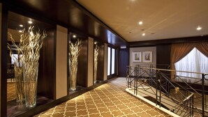 A hotel corridor with patterned carpet, tall decorative vases, and a staircase with metal railings. - Steigenberger Legacy Nile Cruise - Every Monday 07 & 04 Nights from Luxor - Every Friday 03 Nights from Aswan (Luxor)