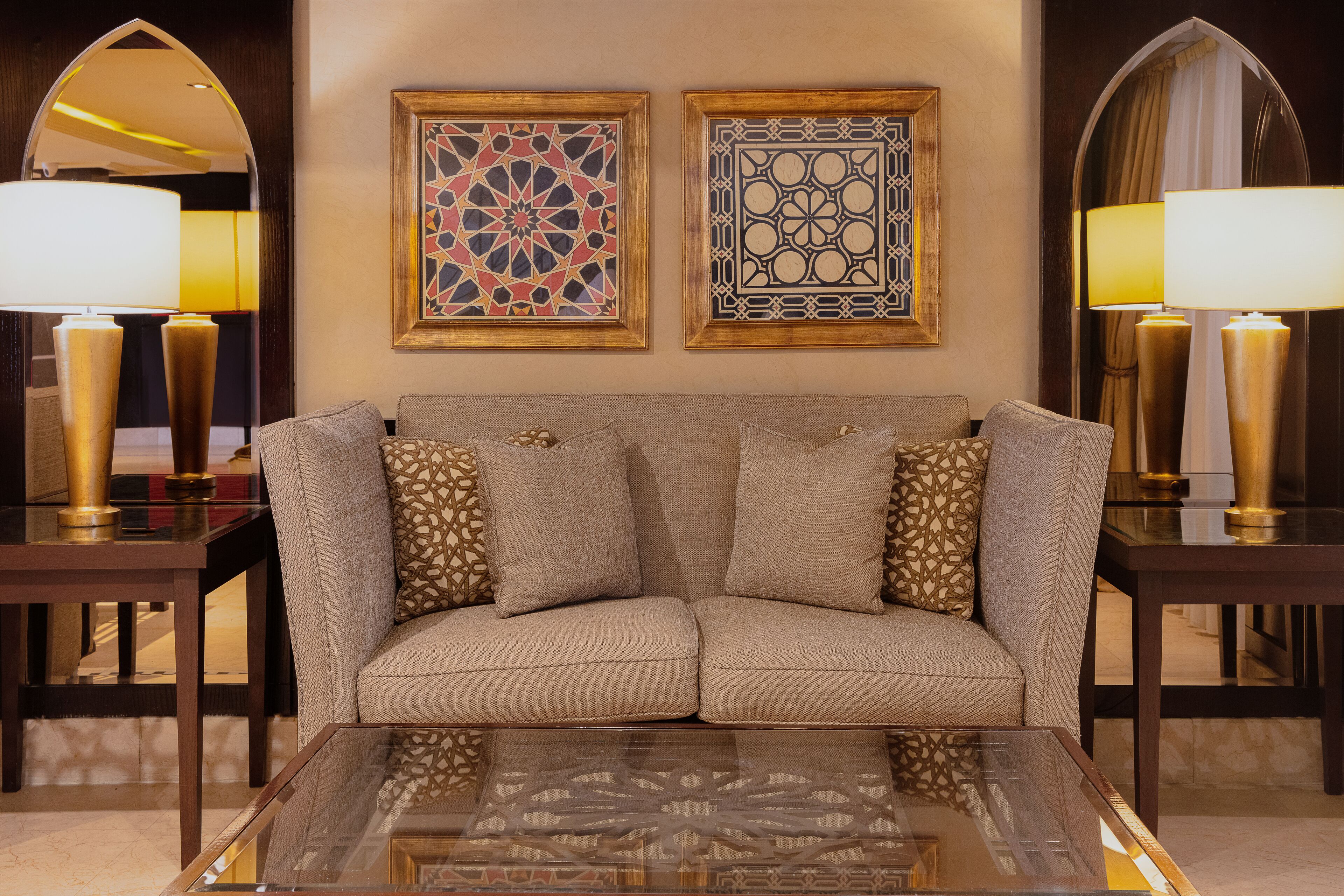 A modern living room with a sofa, two side tables, and two lamps.