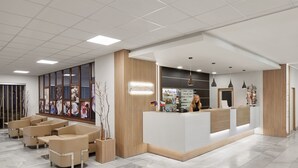 A modern reception area with a white reception desk, beige seating, and a large window displaying artwork. - Hotel Červenohorské sedlo (Loucna nad Desnou)