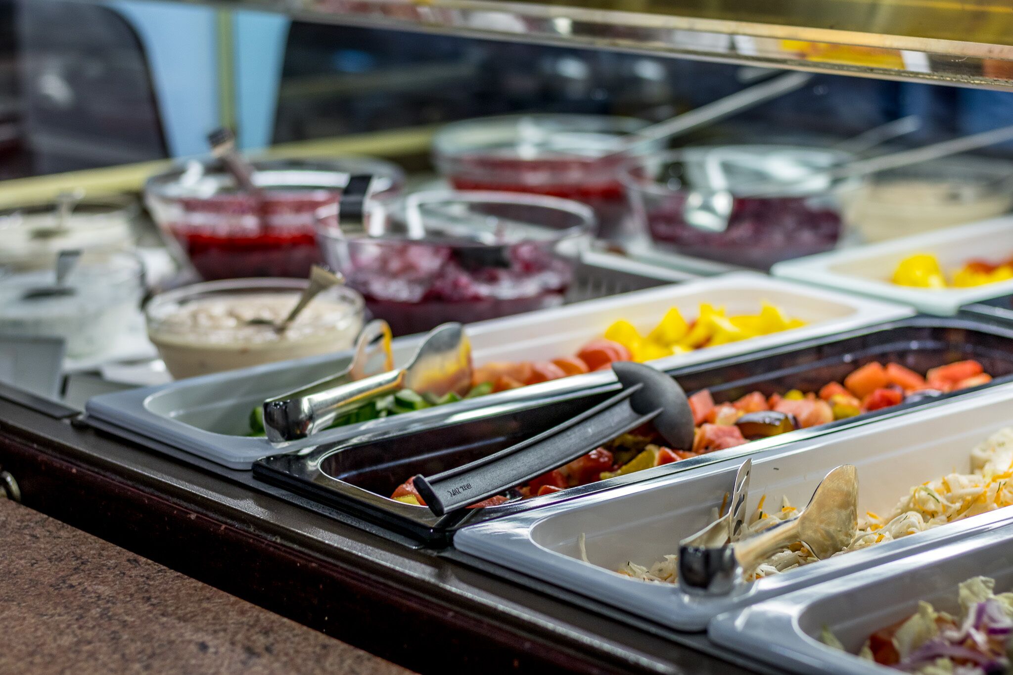 A buffet with various food items and serving utensils.
