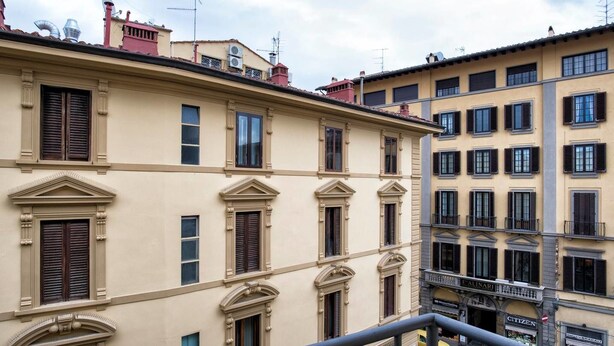 Un edificio de varios pisos con detalles arquitectónicos clásicos, como ventanas simétricas y molduras decorativas.