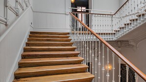 A grand staircase with ornate white railings and a wooden finish.