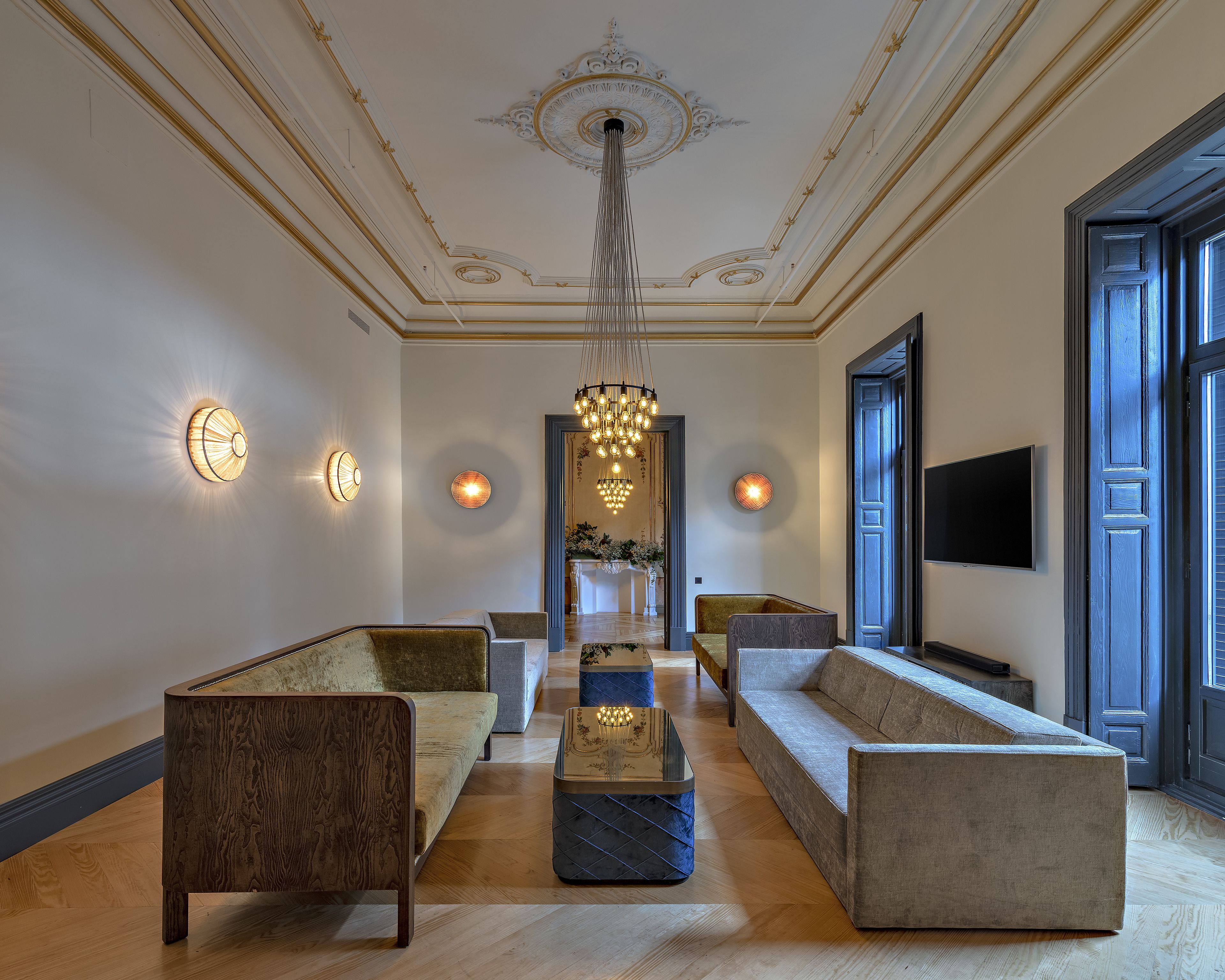 Un hall d’entrée spacieux, doté d’un plafond haut, d’élégants lustres et d’un mobilier moderne.