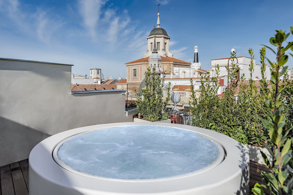 Un jacuzzi sur le toit offrant une vue sur une église et les bâtiments environnants.