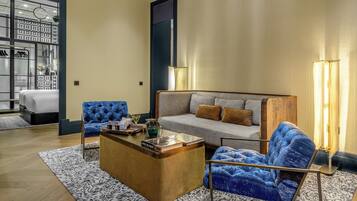 A modern living room with a sofa, blue armchairs, a wooden coffee table, and a patterned rug.