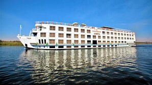 A large river cruise ship with multiple decks and balconies, featuring the name "Steigenberger Minerva" on its side.