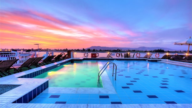 A pool area with lounge chairs and a lifebuoy barrier.