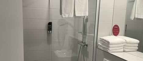 Un baño moderno con ducha envuelta en vidrio, inodoro y lavamanos.