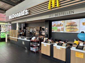 Un restaurante McDonald's con mostrador, carteles de menú y un letrero que indica que es una sucursal de prueba.