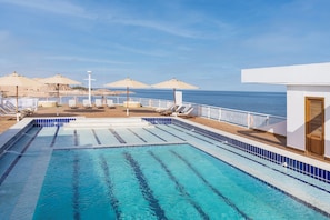 Una piscina al aire libre, sombrillas