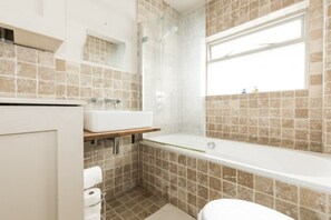 Un baño con bañera, lavabo e inodoro.