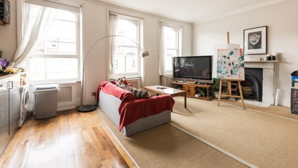 A living room with a sofa, TV, fireplace, and artwork. - Eson2 - The Kensington Gwendwr Road Lodge (London)