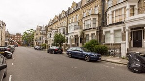 A street lined with terraced houses, parked cars, and a clear road. - Eson2 - The Kensington Gwendwr Road Lodge (London)