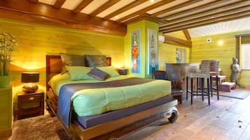 A bedroom with a bed, bedside tables, a chair, and a small table.