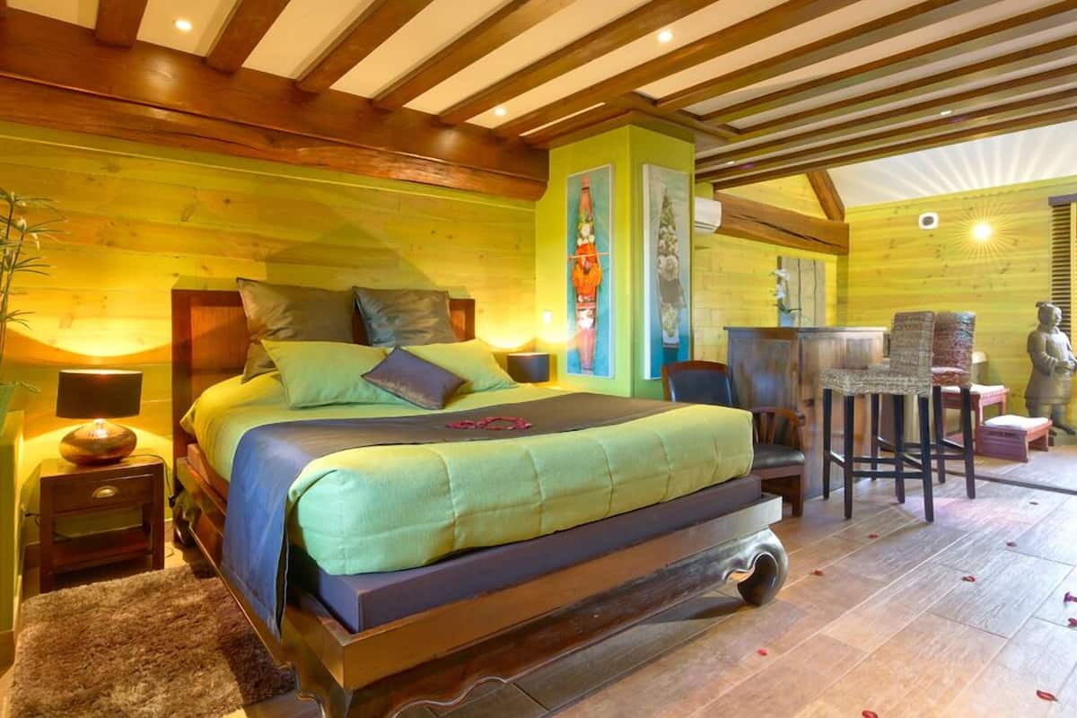A bedroom with a bed, bedside tables, a chair, and a small table.