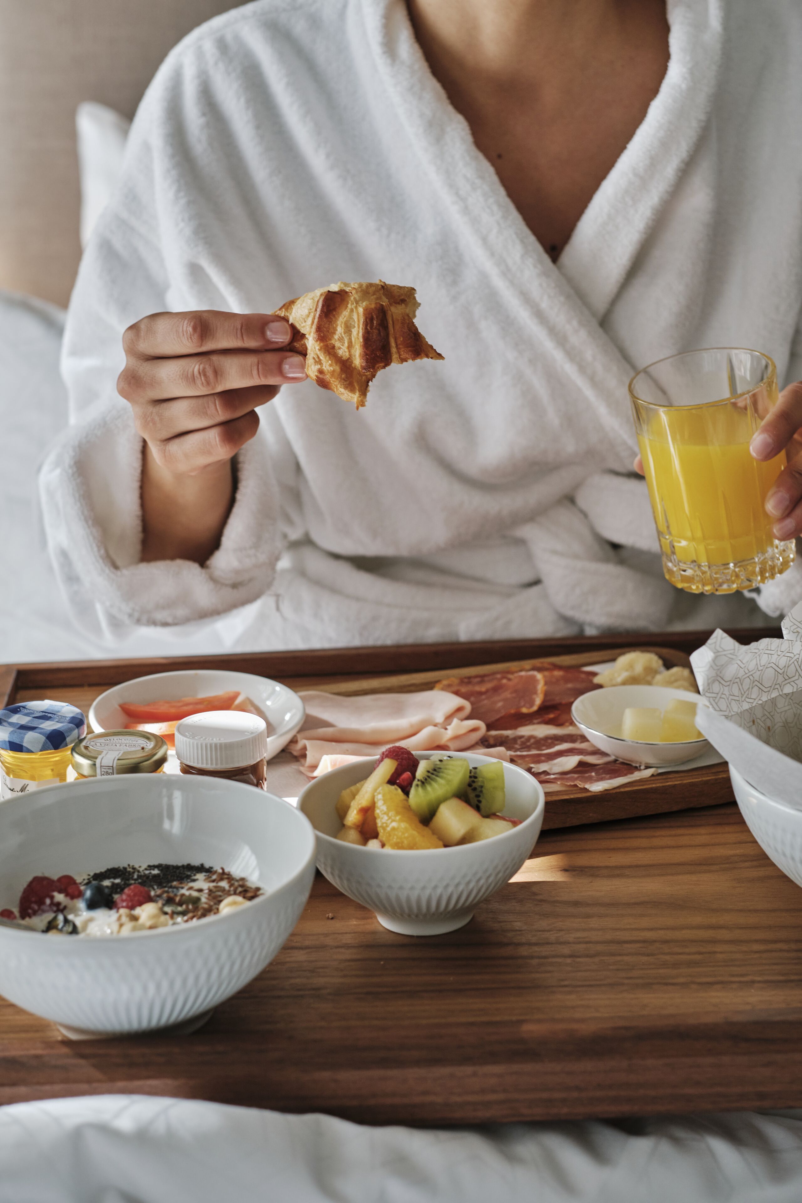 A breakfast tray with various food items and a glass of orange juice.