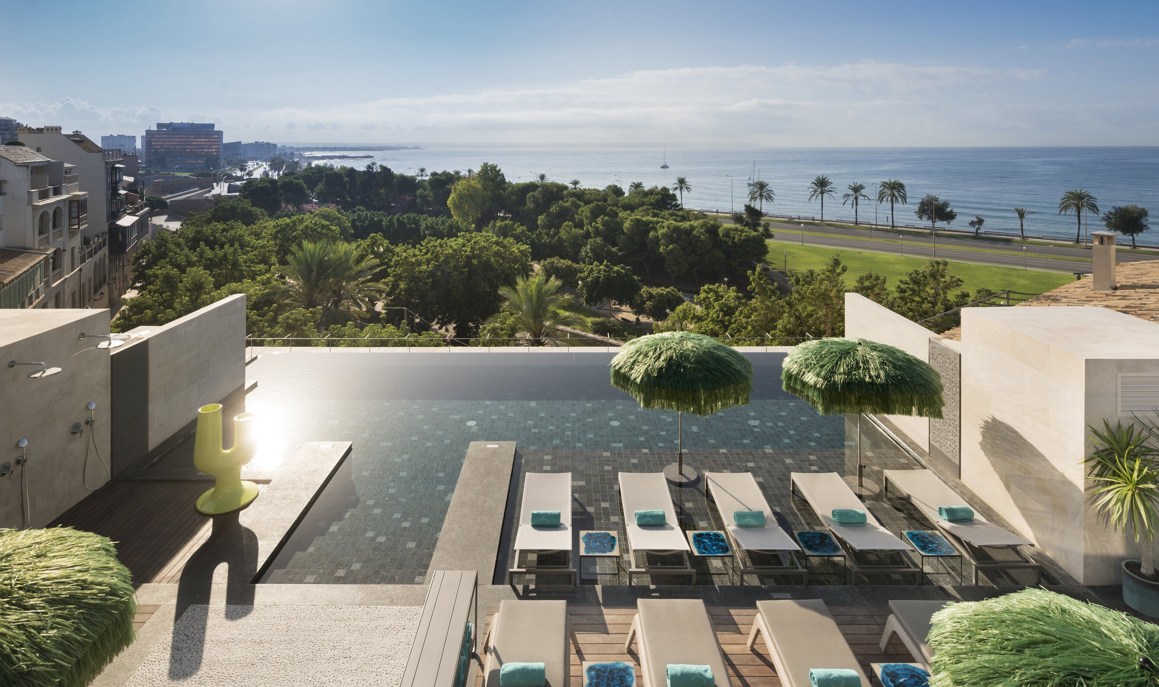 Una piscina techada, una piscina al aire libre, sombrillas