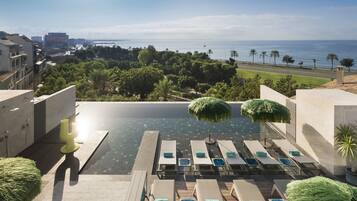 Alberca techada, alberca al aire libre y sombrillas en la alberca