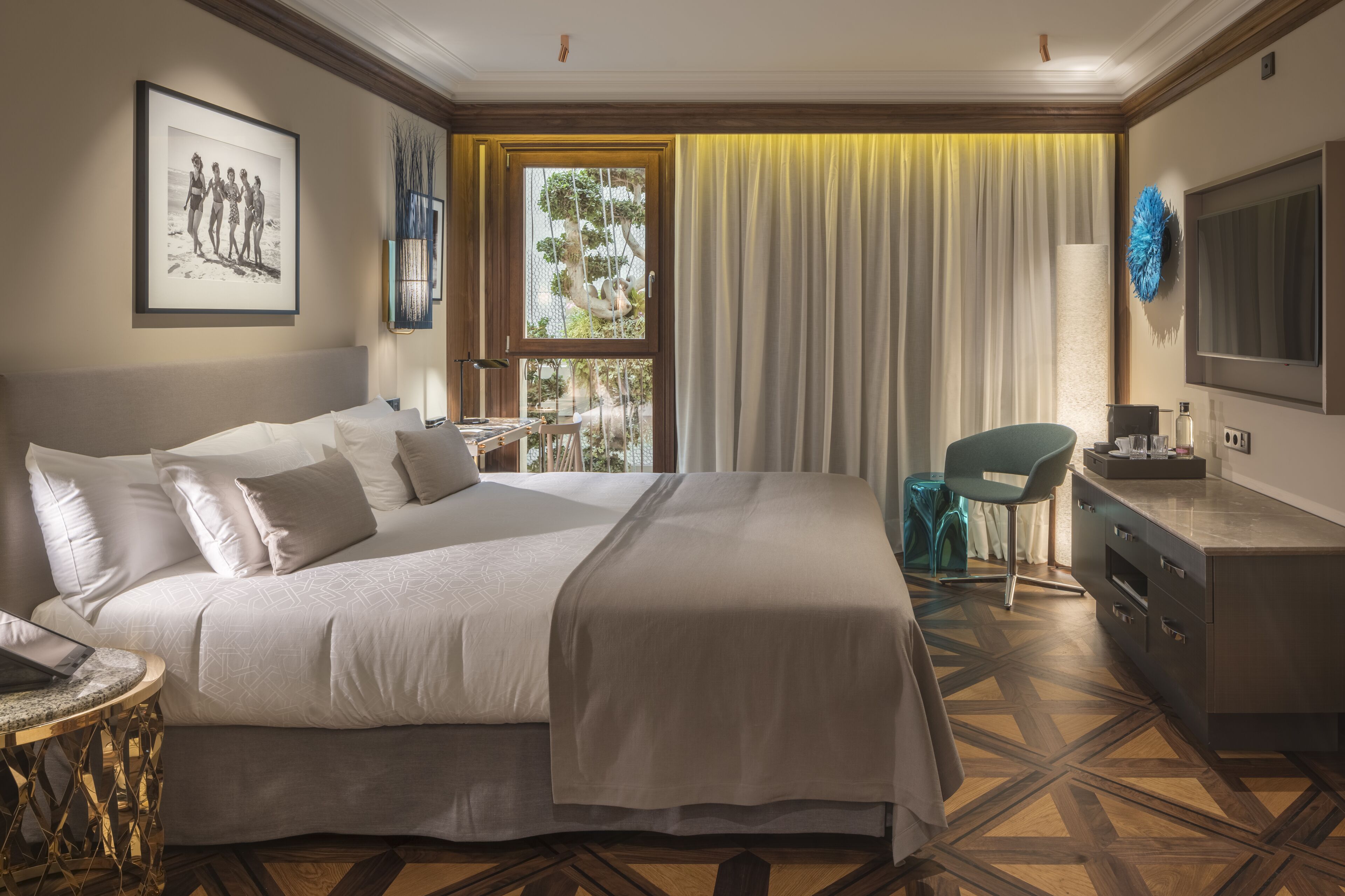 Une chambre d’hôtel bien aménagée, dotée d’un grand lit, d’un bureau, d’une chaise, d’une télévision et d’une fenêtre avec des rideaux.