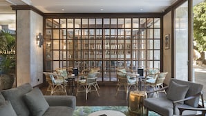 A modern hotel lobby with a seating area featuring wicker chairs and a grey sofa. - Hotel El Llorenç Parc de la Mar - Adults Only (Palma de Mallorca)