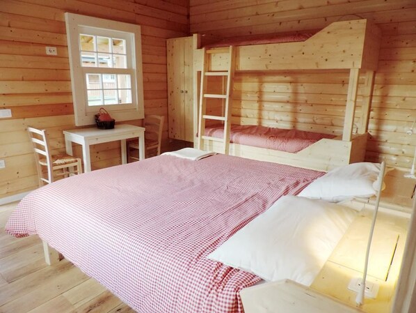 A wooden cabin room with bunk beds, a desk, and a window. - Evolution Wood Accommodation (Sant'Ippolito)