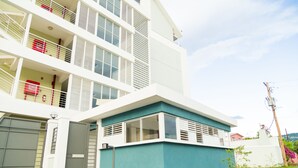 A modern multi-story building with balconies, large windows, and a garage. - Executive Suites at The Bromptons (Kingston)