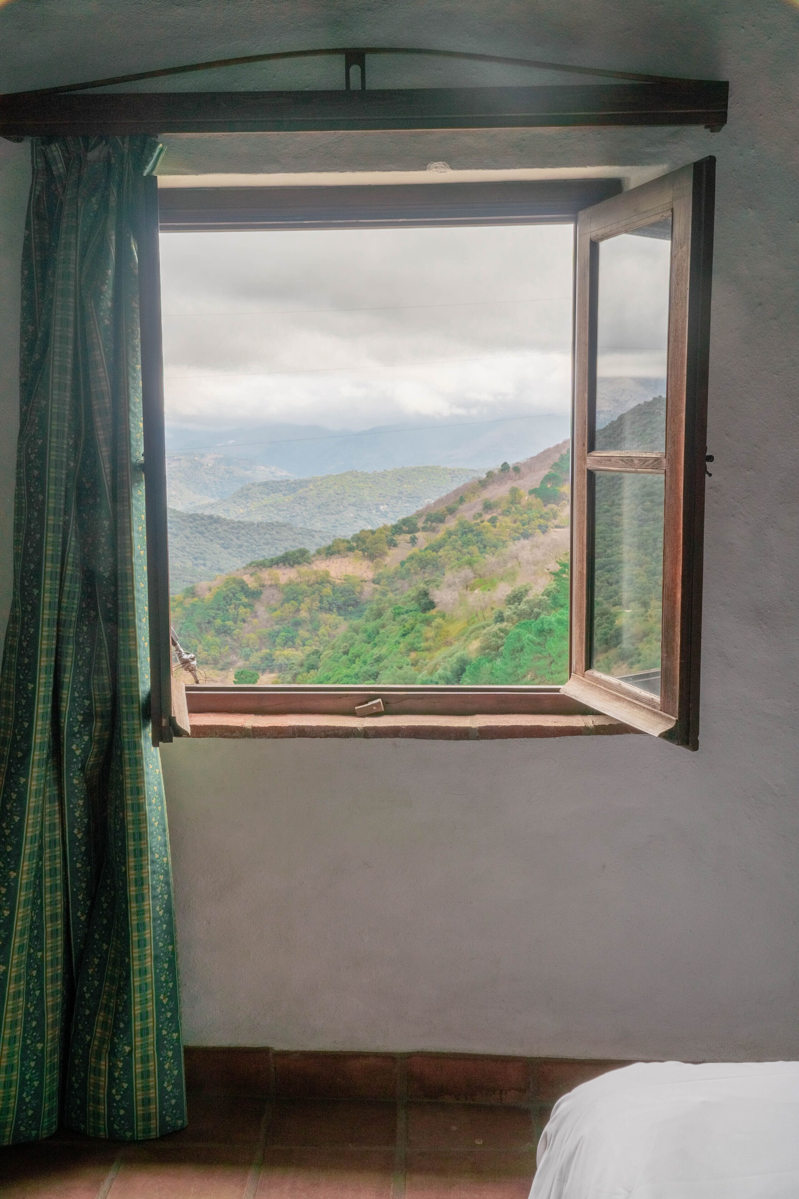 Una habitación con ventana que da a un paisaje montañoso.