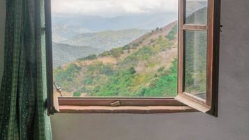 Una habitación con ventana que da a un paisaje montañoso.