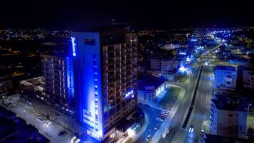 A high-rise hotel with multiple floors, a parking garage, and a busy street with traffic.