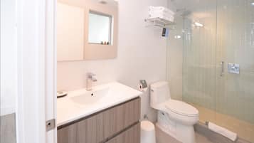 Une salle de bain moderne avec un lavabo blanc, un miroir et des toilettes.