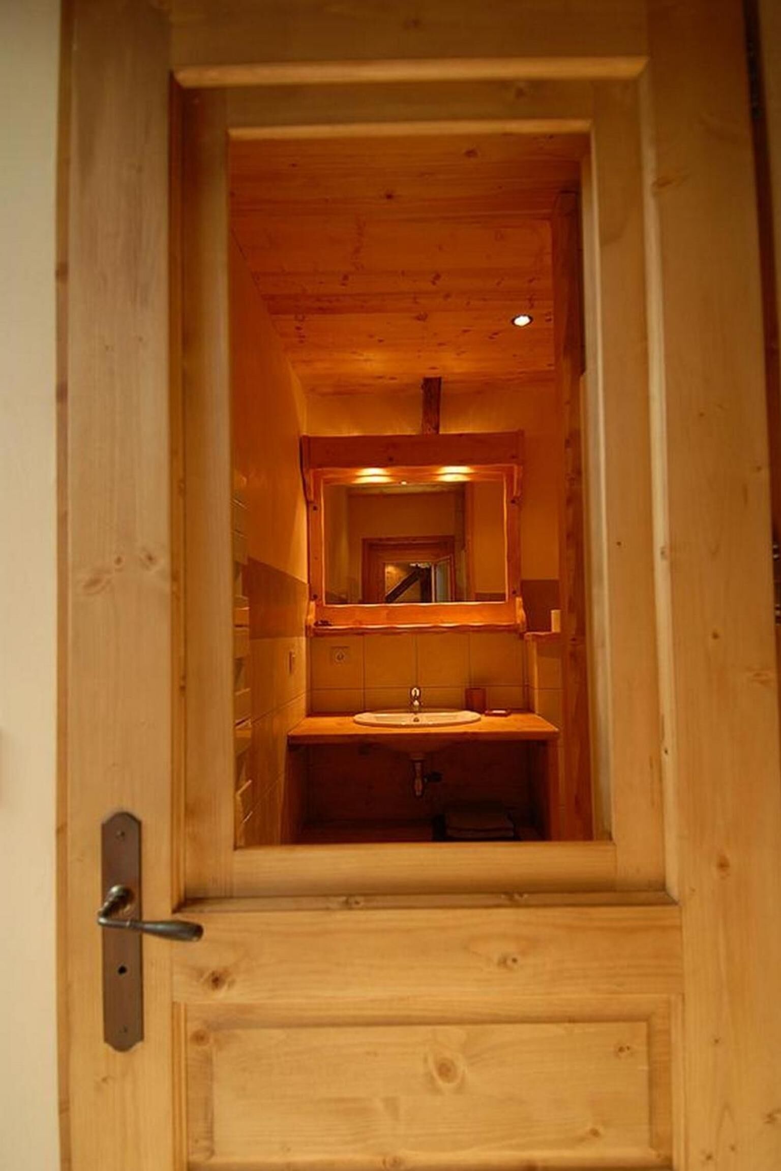 Une salle de bain avec un cadre en bois, comprenant un lavabo et un miroir.