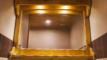 Un bagno con soffitto in legno, un grande specchio, un lavandino e un asciugamano sul ripiano.